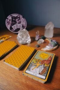 Tarot cards and crystals on wooden table symbolize mysticism and divination.